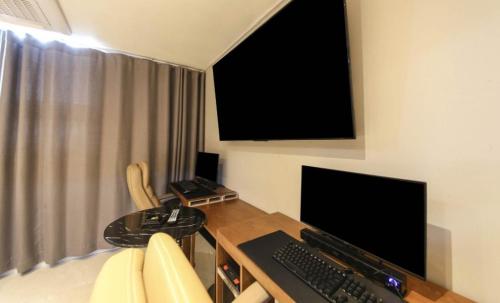 a room with a desk with a keyboard and a monitor at Browndot Hotel Godeok newtown in Pyeongtaek