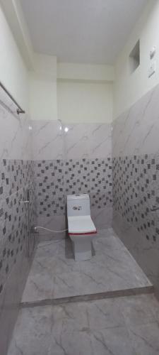 a bathroom with a white toilet in a room at Budget Stay for Family with Atulyam in Prayagraj
