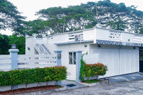 a white building with a staircase on top of it at White House Cabin Cozy Retreat with Rustic Charm in Hermosa