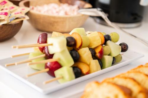 a plate of fruit skewers on a table with bread at Nayah Stays, Ancient Sands Luxurious Pool Terrace Apartment in Hurghada