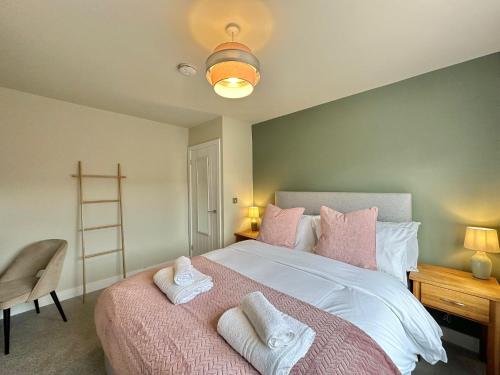 1 dormitorio con 1 cama grande con almohadas rosas y blancas en Contemporary City Centre Apartments with Garden, en Hereford