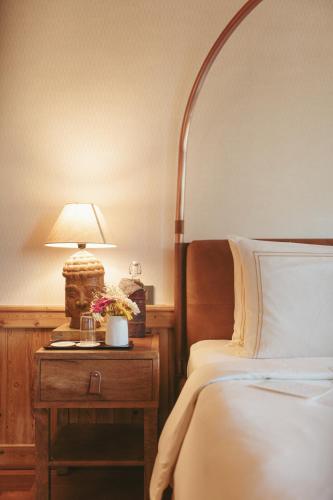 a bedroom with a bed and a table with a lamp at Brij Atmanya Bhowali, Nainital, A Luxury Mountain Escape in Nainital