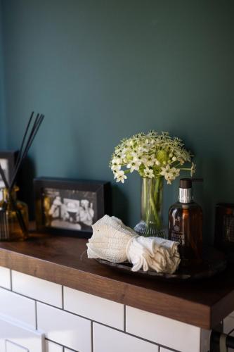a counter with a vase of flowers on it at Villa Hod Couples Suite with Mountain Views in ‘En Hod