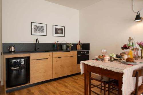 a kitchen with a table and a sink and a dishwasher at Villa Hod Couples Suite with Mountain Views in ‘En Hod