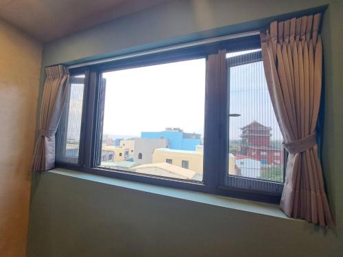 a window with a view of a city at Chunfang Residence in Fangliao