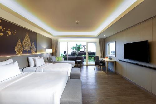 a hotel room with two beds and a flat screen tv at Amaranta Prambanan Yogyakarta in Yogyakarta