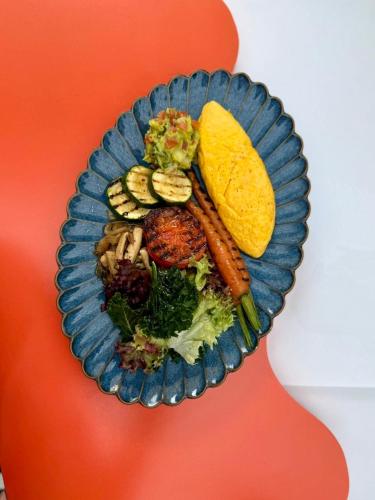 a blue plate of food with vegetables and other foods at The Fig Lobby Bangkok in Bangkok