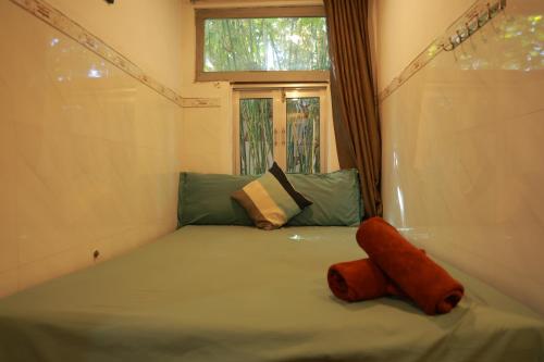 a small bed in a room with a window at EVA HUT Mui Ne Beach Hostel in Mui Ne