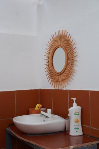 a bathroom with a sink and a mirror at EVA HUT Mui Ne Beach Hostel in Mui Ne