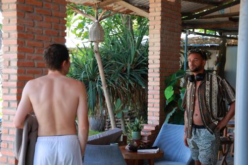 a man with no shirt on standing next to a man in at EVA HUT Mui Ne Beach Hostel in Mui Ne