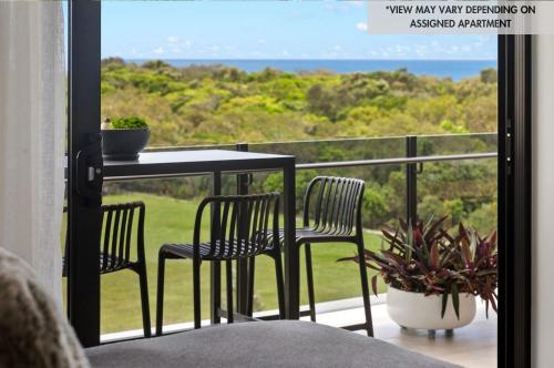 a balcony with two chairs and a table and a view of the ocean at Bokarina Beach Apartments, an Ascend Collection Hotel in Bokarina