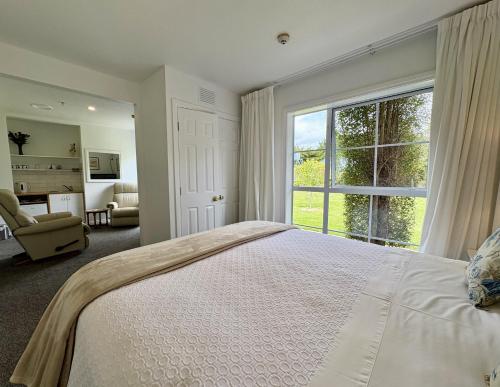 a bedroom with a large bed and a large window at 64 Mandalea B&B in Ohoka