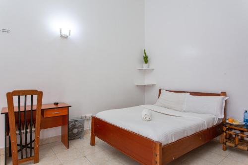 a small bedroom with a bed and a desk at Bonsai Villa in Nairobi