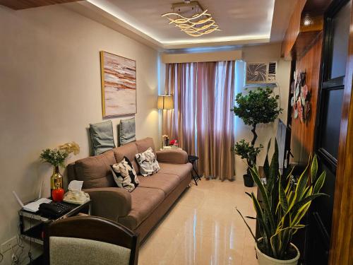 a living room with a brown couch and a window at Executive Suite Condo 1 in Dumaguete