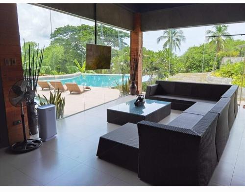 a living room with a couch and a table and a pool at Zaruchi Villa Argao in Argao