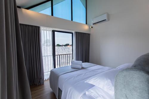 a bedroom with a white bed and a large window at 20 Suites Umalas in Canggu
