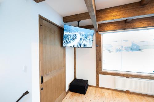 a room with a flat screen tv on the wall at Oreo Niseko 新築 ニセコ中心地 駐車場2台完備 in Kutchan