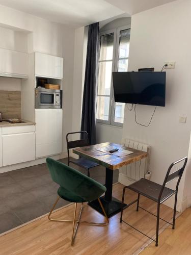 - un salon avec une table et une chaise verte dans l'établissement Cosy studio 20m2 Marseille Vieux-Port, à Marseille