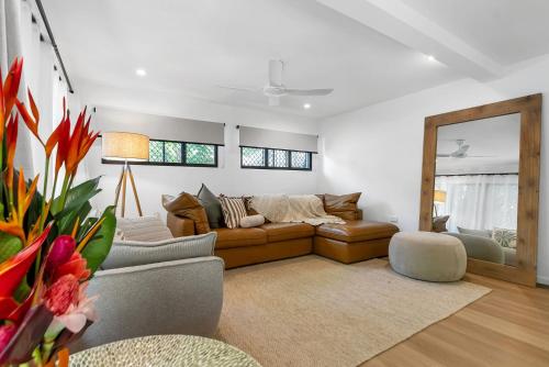 a living room with a couch and a mirror at Belle Escapes Sun Rose in Palm Cove in Palm Cove