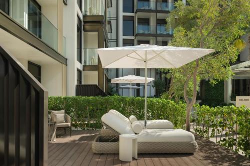 a white chair and an umbrella on a patio at Delano Dubai at Bluewaters in Dubai
