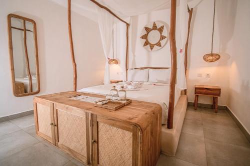 a bedroom with a bed with a wooden table at Quma Boutique Hotel - Adults Only in Gili Trawangan