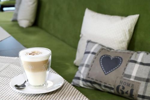 een kopje koffie zittend op een tafel met een lepel bij Pension Dalinghaus in Vörden