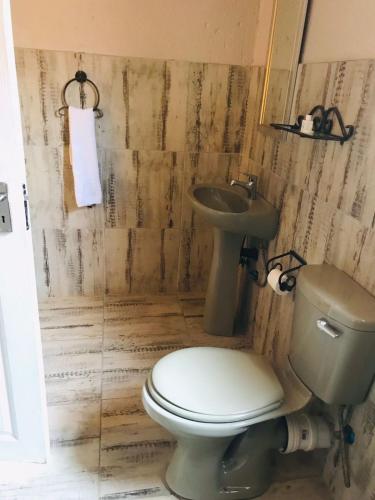 a bathroom with a toilet and a sink at Kanyane Lodge in Jane Furse