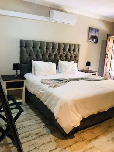 a large bed with a large headboard in a bedroom at Kanyane Lodge in Jane Furse