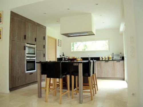 une cuisine avec un îlot noir au milieu dans l'établissement Au coeur du bassin...à vélo, au Teich