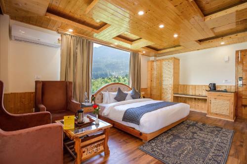 a bedroom with a bed and a couch and a chair at Tripli Hotels Namaste Manali in Manāli