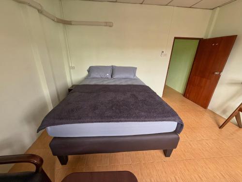 a bedroom with a bed in a room with a door at Penny Hostel & Cafe in Thongsala