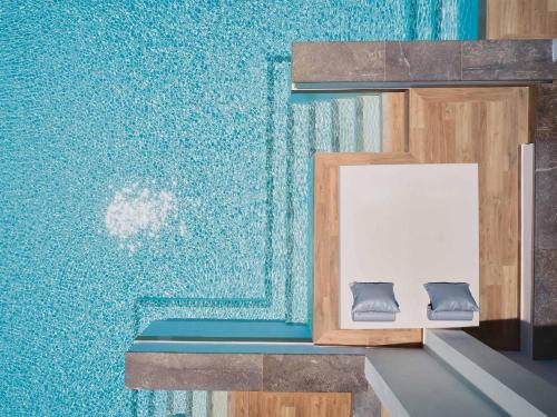 a room with a blue wall with a bench at Grecotel LUXME White in Adelianos Kampos