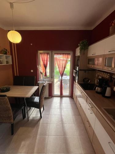 a kitchen with a table and a dining room at Tejfeles vendégház in Porva