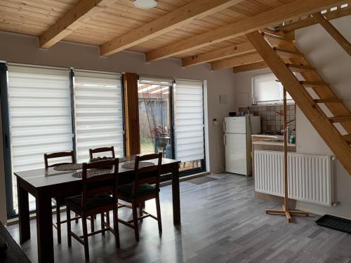 a kitchen and dining room with a table and chairs at Tejfeles vendégház in Porva