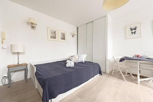 une chambre blanche avec un lit et un bureau dans l'établissement Aurore - Studio 1, à Carcassonne
