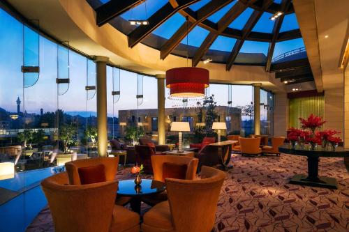 a hotel lobby with chairs and tables and windows at Grand Hyatt Amman in Amman