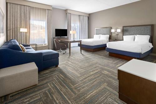 a hotel room with two beds and a couch at Hampton Inn & Suites Wells-Ogunquit in Wells