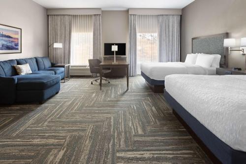 a hotel room with two beds and a couch at Hampton Inn & Suites Wells-Ogunquit in Wells