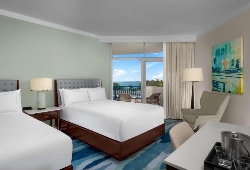 a hotel room with a bed and a balcony at Hilton Aruba Caribbean Resort & Casino in Palm-Eagle Beach