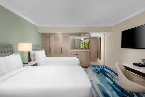 a hotel room with two beds and a flat screen tv at Hilton Aruba Caribbean Resort & Casino in Palm-Eagle Beach