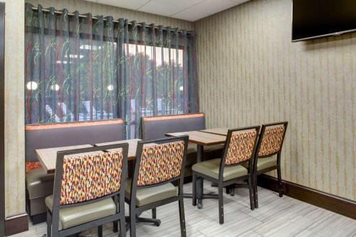 a dining room with a table and chairs and a window at Clarion Inn Biltmore Village in Asheville