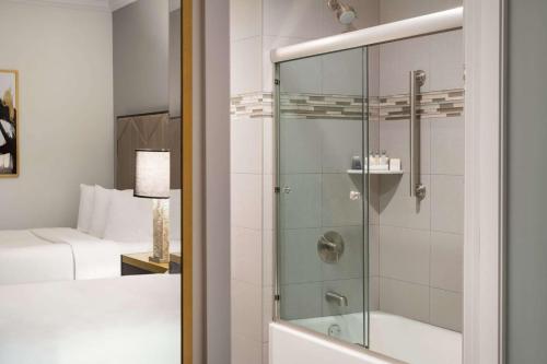纽约Martinique New York on Broadway, Curio Collection by Hilton的带淋浴和玻璃门的浴室