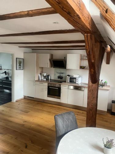 a kitchen with white cabinets and a table in a room at Gästehaus an der Frauenkirche in Günzburg