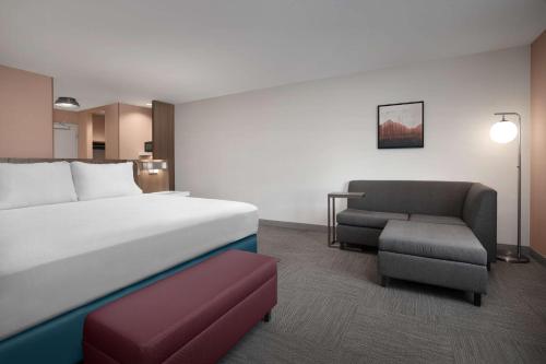 a hotel room with a bed and a chair at Hilton Garden Inn Denver Airport Tower Road in Denver