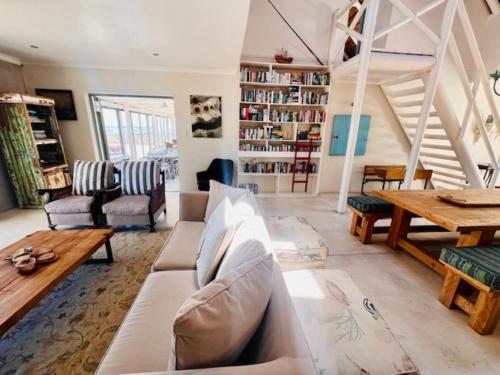 a living room with a couch and a table at Bamboesbaai Beach House in Jacobs Bay