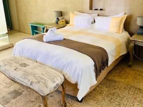 a bedroom with a large bed with a teddy bear on it at Bamboesbaai Beach House in Jacobs Bay