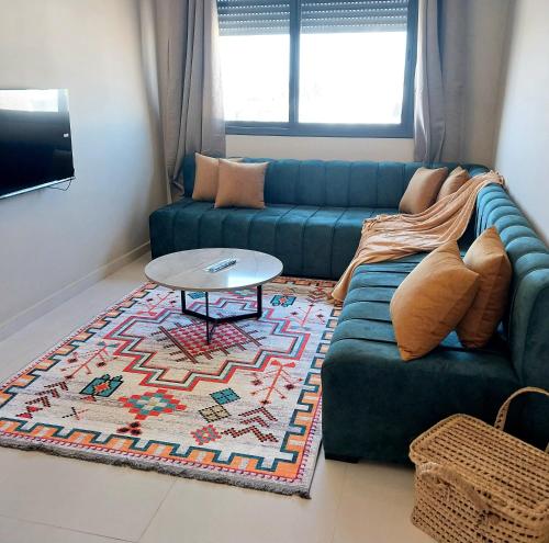 a living room with a blue couch and a table at Airport mohamed 5 break apartments in Derroua
