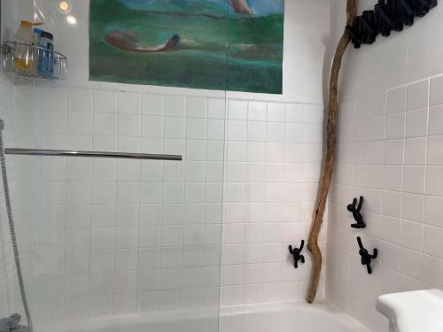 La salle de bains est pourvue d'une douche, d'une baignoire blanche et d'un tableau. dans l'établissement Appart 2 pièces 4 couchages BANYULS SUR MER BN100-E541, à Banyuls-sur-Mer