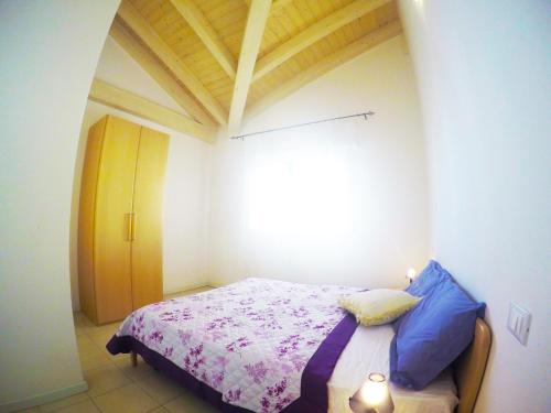 カオルレにあるResidenza Anna Giulia - Agenzia Cocalの小さなベッドルーム(青い枕のベッド付)