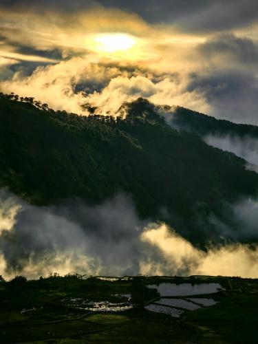 a view of a mountain with clouds in the sky at Catlin's Cabin and Cafe in Sagada
